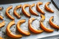 Hot roasted slices pumpkin with thyme, olive oil and salt on baking paper. Tasty vegan food