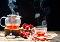 Hot roselle tea is poured from a kettle into glass cup with steam. Organic and Summer drink Royalty Free Stock Photo