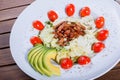 Hot salad with fried meat, lettuce, tomato and avocado on wooden table. Hot Meat Dishes. Top view Royalty Free Stock Photo