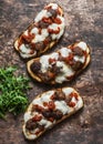 Hot sandwiches with meatballs, tomato sauce, mozzarella and arugula on wooden table, top view. Royalty Free Stock Photo