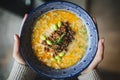 Hot satisfying tantanmen ramen bowl in female hands, top view, horizontal