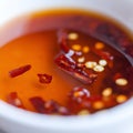 Hot sauce of red dry chili peppers with soy oil in a white bowl close-up Royalty Free Stock Photo