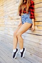 Hot tan slim woman legs in sneakers and jeans shorts - clos Royalty Free Stock Photo