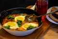 In hot shakshuka tomatoes sweet peppers eggs and herbs