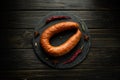 Hot smoked meat sausage on a black sorting board with rosemary and pepper. Concept of preparing and serving Munich sausage in a Royalty Free Stock Photo
