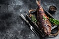 Hot smoked pike perch or zander fish in a wooden tray. Black background. Top view. Copy space