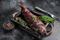Hot smoked pike perch or zander fish in a wooden tray. Black background. Top view