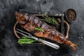 Hot smoked pike perch or zander fish in a wooden tray. Black background. Top view