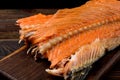 Hot smoked salmon trim and leftovers with bones and fins on dark wooden background