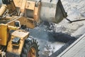 Hot smoking asphalt excavator ejects from the bucket. paving with a tractor Royalty Free Stock Photo