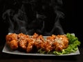 Hot and spicy bbq chicken wings with with green salad leaf and steam smoke Royalty Free Stock Photo