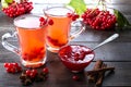 Hot spicy beverage with viburnum in glass cups with fresh viburnum berries and cinnamon sticks, anise stars