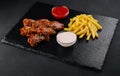 Hot and spicy buffalo chicken wings and french fries Royalty Free Stock Photo