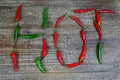 Hot spicy food symbol concept: Close up of green red Chillies forming the word hot on wood table Royalty Free Stock Photo