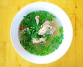 Hot and spicy hot pork ribs with fresh chili and coriander on wooden background