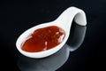 Hot spicy sauce in special white spoon