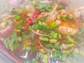 Hot and spicy soup with pork ribs, or Tom Saeb Kraduk Moo, Thai style food. Tom yum pork cartilage soup with chili and onion leaf