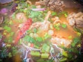 Hot and spicy soup with pork ribs, or Tom Saeb Kraduk Moo, Thai style food. Tom yum pork cartilage soup with chili and onion leaf