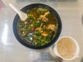 Hot and spicy soup with pork ribs, or Tom Saeb Kraduk Moo, Thai style food. Tom yum pork cartilage soup with chili and onion leaf