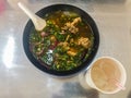 Hot and spicy soup with pork ribs, or Tom Saeb Kraduk Moo, Thai style food. Tom yum pork cartilage soup with chili and onion leaf