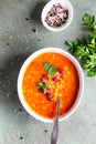 Hot and spicy, thick lentil and red bean soup with canned tomatoes and coriander. Concrete background, selective focus. Top view