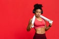 Hot sporty girl with towel and headset over red background Royalty Free Stock Photo