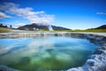 a hot spring with an active volcano in the distance Royalty Free Stock Photo