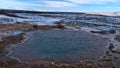 Hot spring with steaming pool of water in Geysir in geothermal area Haukadalur, part of Golden Circle, Iceland in winter. Royalty Free Stock Photo