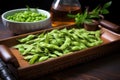 hot, steamed edamame arranged on rustic serving tray