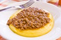 Hot and steaming corn polenta topped with meat ragout sauce ready for your meal