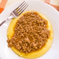 Hot and steaming corn polenta topped with meat ragout sauce ready for your meal