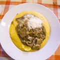 Hot and steaming corn polenta topped with mushroom sauce ready for your meal