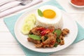 Hot stir-fried pork slices with holy basil leaves served with cooked rice topped with a fried egg Royalty Free Stock Photo