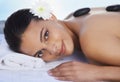 Hot stone massages feel fantastic. A beautiful woman receiving a hot stone massage. Royalty Free Stock Photo