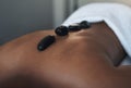 Hot stones penetrate deep into sore muscles. Closeups shot of an unrecognisable man getting a hot stone massage at a spa Royalty Free Stock Photo