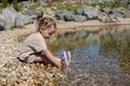 On a hot summer day a beautiful little girl sits at the water& x27;s edge on the shore Child on the beach on the shore of Royalty Free Stock Photo