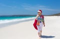 Christmas down on the beach summer sun female walking with santa Royalty Free Stock Photo