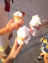 Hot summer, three young women`s hands holding three ice creams in the cornet