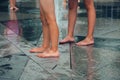 Hot summer weather, small children`s feet bathe in the city fountain. Selective focus