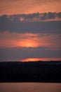 Hot sunset above the forest. Refelctions of red clouds in the water of the lake. bright colors at the end of a summer day