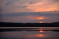 Hot sunset above the forest. Refelctions of red clouds in the water of the lake. bright colors at the end of a summer day Royalty Free Stock Photo