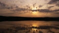 Hot sunset above the forest. Refelctions of red clouds in the water of the lake. bright colors at the end of a summer day