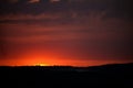 Hot sunset above the forest. Refelctions of red clouds in the water of the lake. bright colors at the end of a summer day Royalty Free Stock Photo