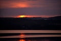 Hot sunset above the forest. Refelctions of red clouds in the water of the lake. bright colors at the end of a summer day Royalty Free Stock Photo