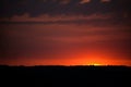 Hot sunset above the forest. Refelctions of red clouds in the water of the lake. bright colors at the end of a summer day Royalty Free Stock Photo