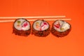 Hot sushi on a stick. Fried sushi. Japanese food on an orange background. Creative serving of the dish Royalty Free Stock Photo