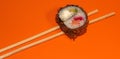 Hot sushi on a stick. Fried sushi. Japanese food on an orange background. Creative serving of the dish Royalty Free Stock Photo