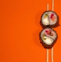 Hot sushi on a stick. Fried sushi. Japanese food on an orange background. Creative serving of the dish Royalty Free Stock Photo