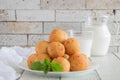 Sweet doughnuts, a decanter of milk and a glass of milk on the table.