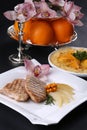 Hot and tasty roasted meat on white dish, decorated with oranges, orchids